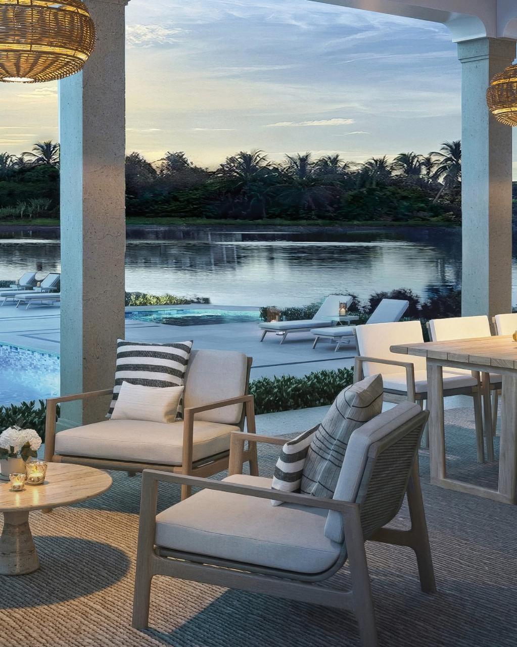 Modern living room with a blue sofa, beige armchair, and glass coffee tables